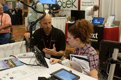 RESNA 2015 Exhibit Hall showing exhibitor interaction with attendee