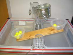 Figure 5 shows the wood teeter totter.  A whole has been bored in the exact center through which a threaded rod is run.  The rod is bolted to two plastic pieces mounted to another piece of plastic that is bolted to the table.