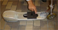 Picture of small electric scooter with a human hand pointing to the &ldquo;peg&rdquo; welded onto footboard.